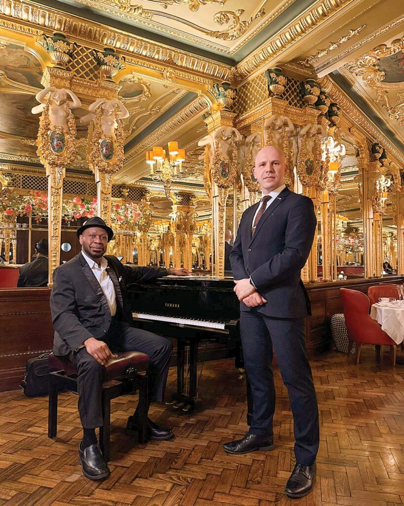 Tea sommelier Luigi Vergura, right, poses next to accomplished pianist Arnold Khanu in the ornate tea salon.