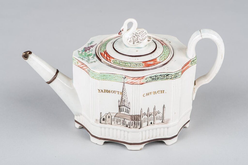 Pearlware teapot painted with an image of Yarmouth church by William Absolon, who bought wares from Wedgwood, Davenport, Turner, and Staffordshire factories and decorated them at his works in Yarmouth.