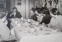 Vida and other young ladies excitedly enjoy afternoon tea with English actor Roger Moore at Elstree Studios.